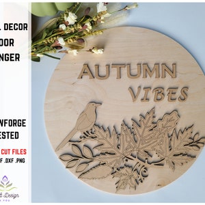 May include: A wooden round door hanger with the text "AUTUMN VIBES" and a bird perched on a branch with leaves. The design is laser cut and ready to be painted.