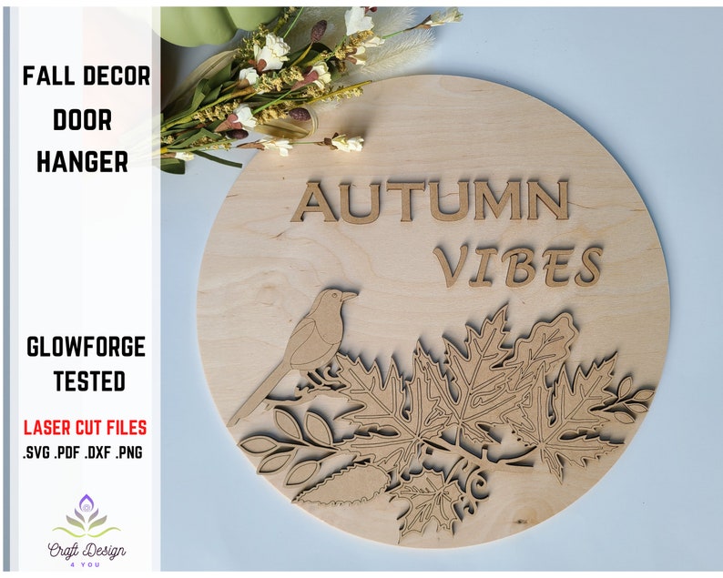 May include: A wooden round door hanger with the text "AUTUMN VIBES" and a bird perched on a branch with leaves. The design is laser cut and ready to be painted.