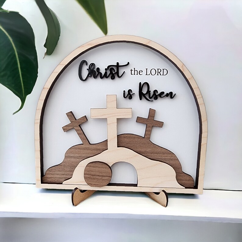 May include: Wooden Easter cross and tomb scene with the text "Christ the LORD is Risen".