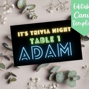 May include: Editable Canva template for a trivia night table sign. The sign has a black background with neon green and blue text that reads "It's Trivia Night Table 1 Adam".