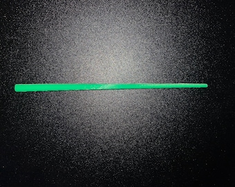 May include: A thin, bright green plastic stick, approximately 12 inches long.