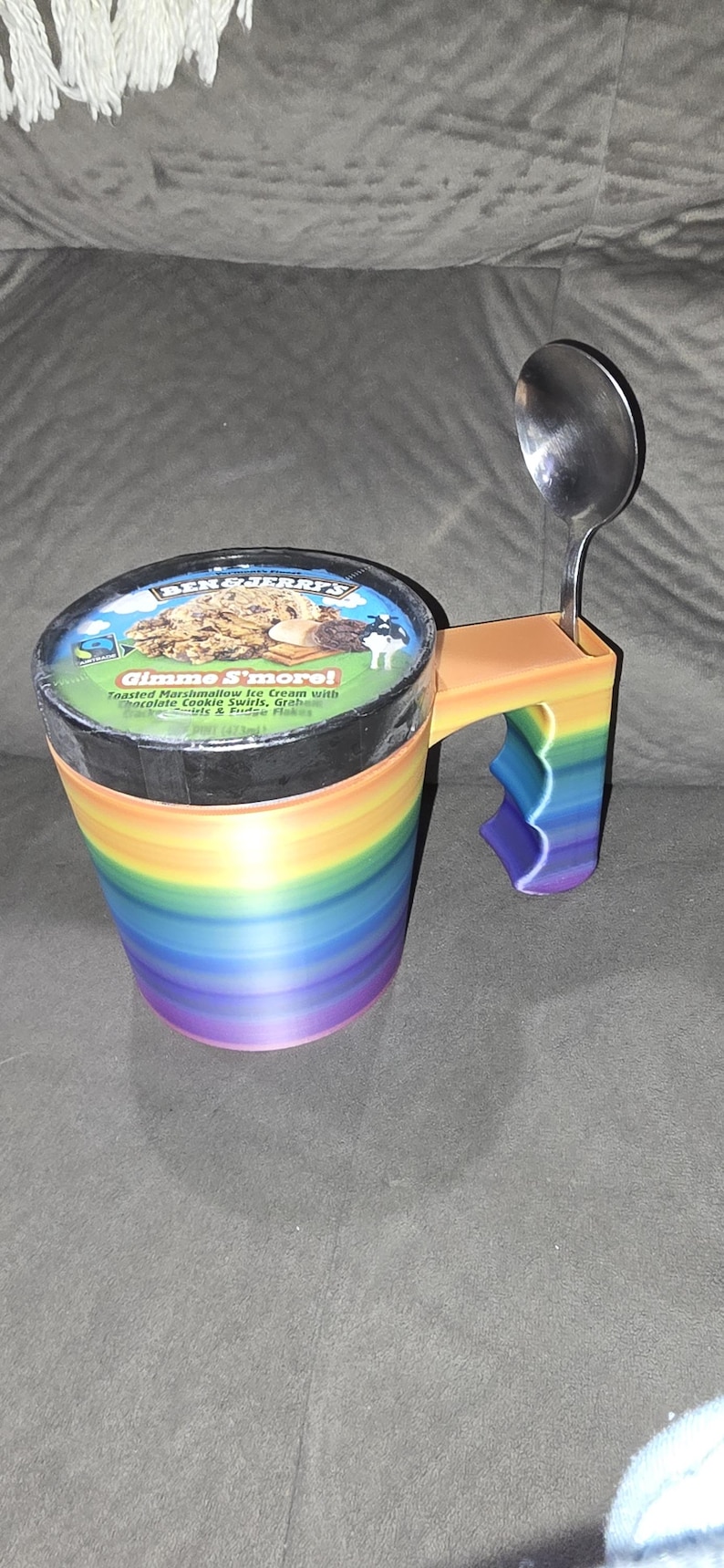 Może przedstawiać: Kubek na lody w kolorze tęczy z uchwytem i łyżką. Kubek jest oznaczony napisem "Gimme S'more!" i przedstawia zdjęcie lod&oacute;w z prażonym marshmallow z czekoladowymi wi&oacute;rkami, krakersami graham i płatkami fudge.