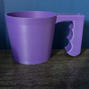 Może przedstawiać: Fioletowy plastikowy kubek miarowy z uchwytem. Kubek ma gładką powierzchnię i zaokrąglone dno.