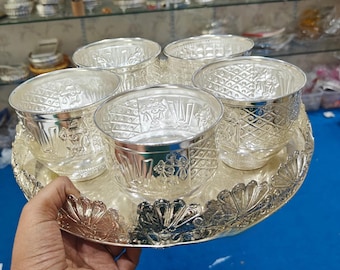 Puede incluir: Una bandeja de servir de plata con cinco cuencos de plata. La bandeja y los cuencos tienen un diseño adornado y en relieve.