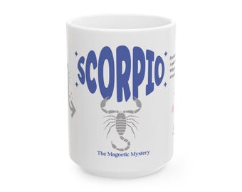 May include: White ceramic mug featuring the word "SCORPIO" in blue, with a gray scorpion illustration below. The mug also includes the text "The Magnetic Mystery" and astrological details.