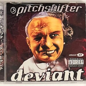 May include: A CD case with a red background and a close-up image of a person with a crown on their head. The person is smiling with a mischievous expression. The text "pitchshifter" is at the top of the case, and the text "deviant" is at the bottom. The case also has a Parental Advisory sticker.
