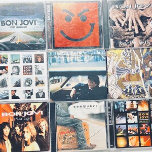 May include: A collection of nine compact discs featuring the rock band Bon Jovi. The album titles include "Lost Highway", "Keep the Faith", "These Days", "Crush", "Destination Anywhere", and "This Left Feels Right".