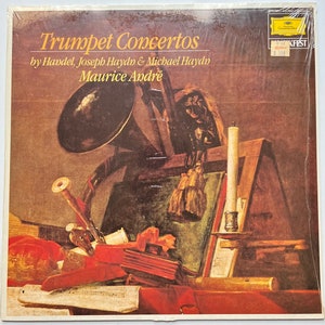 May include: A vintage vinyl record album cover featuring a painting of a trumpet, a candle, and other musical instruments. The album title is "Trumpet Concertos" by Handel, Joseph Haydn & Michael Haydn, performed by Maurice Andre.