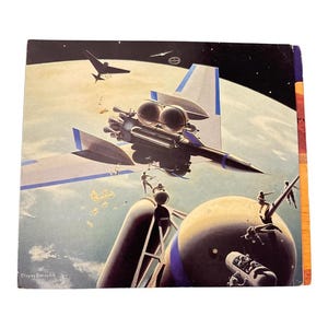 May include: Vintage science fiction book cover art featuring a futuristic spacecraft with a black and silver design, flying over a planet. The artwork includes figures on a structure and other flying objects in the sky.