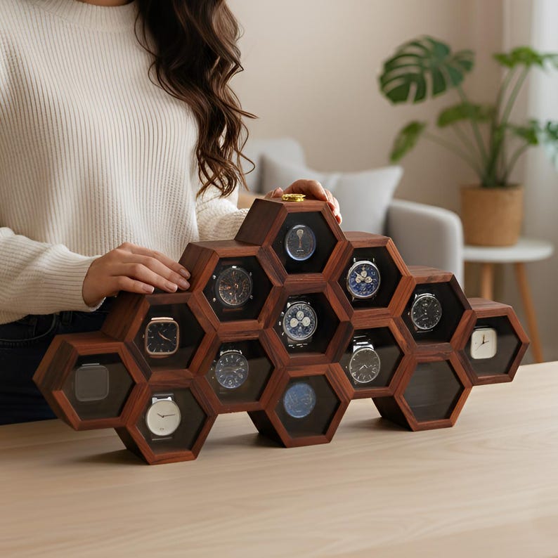 May include: A dark brown wooden display case featuring a honeycomb structure with multiple hexagonal compartments. Each compartment contains a wristwatch with a unique face and dial design. The display case is arranged in a tiered, geometric pattern.