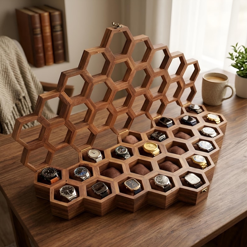 May include: A wooden watch display case featuring a honeycomb-inspired hexagonal grid design. The open lid reveals multiple individual compartments, each containing a wristwatch resting on a brown cushion, organised within the geometric wooden frame.