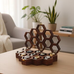 May include: A dark brown wooden watch display case featuring a honeycomb-inspired design with multiple hexagonal compartments. The open lid reveals a geometric structure, while the base holds several wristwatches with metallic bands.