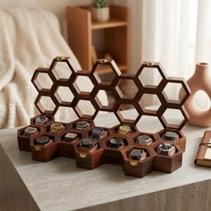 May include: A dark brown wooden watch display case featuring a honeycomb structure with multiple hexagonal compartments. The open lid reveals a matching hexagonal frame, while the base contains individual slots holding various wristwatches.