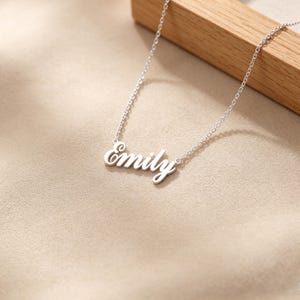 May include: A white ceramic mug with a black handle and the text "But First, Coffee" in a black, bold font. The mug is on a white surface.