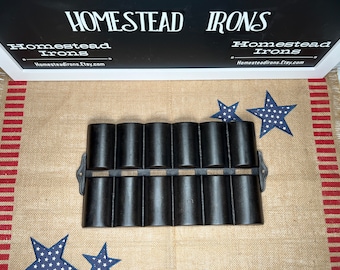 May include: A black cast iron muffin pan with eight individual molds. The pan has a rustic look and is perfect for baking muffins, cupcakes, or other small treats.