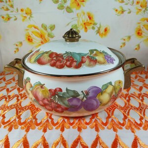 May include: White enamel pot with a gold lid and handles. The pot is decorated with a colourful fruit design, including cherries, apples, pears, and plums.