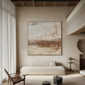 May include: Abstract painting with brown and white hues. The painting is on a canvas and has a textured surface. The painting is hanging on a wall in a living room setting.