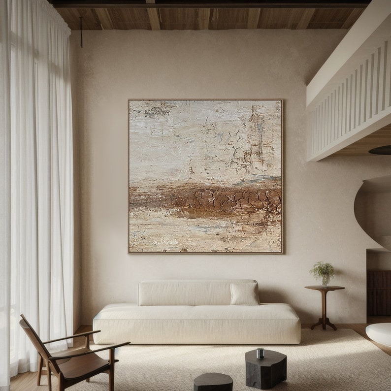 May include: Abstract painting with brown and white hues. The painting is on a canvas and has a textured surface. The painting is hanging on a wall in a living room setting.