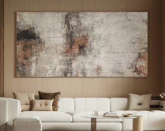 May include: Abstract painting with brown, gray, and white colors. The painting is hanging on a wall above a white couch with pillows.
