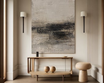 May include: Abstract textured painting in neutral tones of gray, black, and beige, mounted above a wooden console table. The room features a minimalist design with a wooden coffee table, decorative spheres, and a mushroom-shaped stool. Wall sconces flank the artwork.