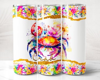 May include: A white tumbler with a colorful watercolor design of a crab and flowers. The tumbler has a gold glitter band around the top and bottom. The text "Crab" is written in gold glitter on the tumbler.