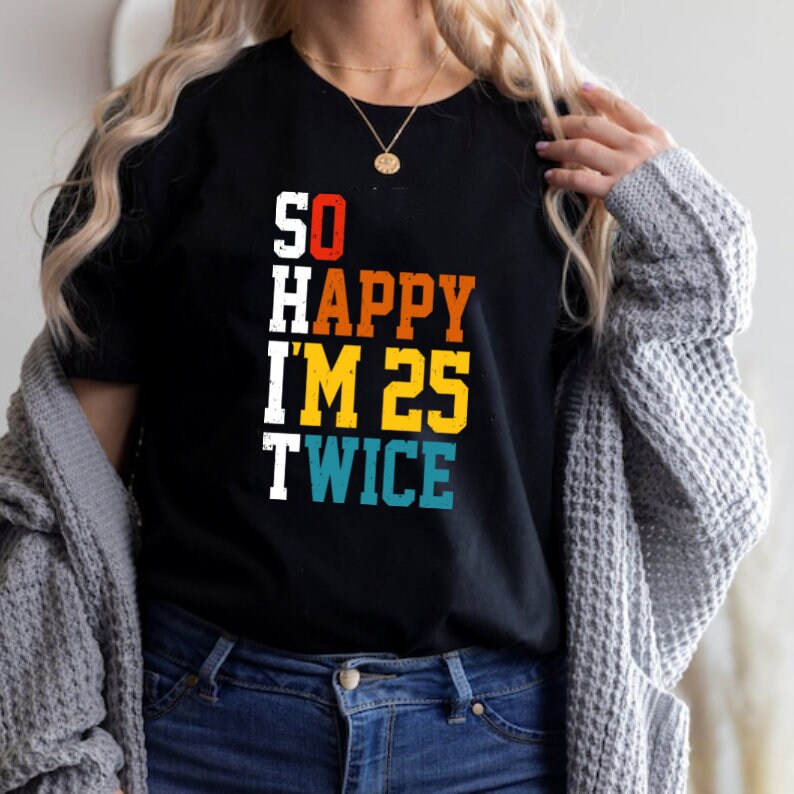 May include: Black t-shirt with a vintage-style graphic that reads "SO HAPPY I'M 25 TWICE". The text is in different colors, including red, yellow, blue, and green.