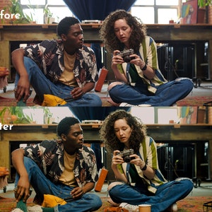 May include: Two people are sitting on a rug, one holding a vintage camera. They are wearing casual clothing, including a striped shirt, a floral shirt, and ripped jeans. The scene is set in a room with a large wooden table and artwork.