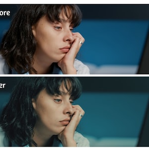 May include: A woman with dark hair is sitting in front of a computer screen. She is looking at the screen with a tired expression. The background is a blue wall.