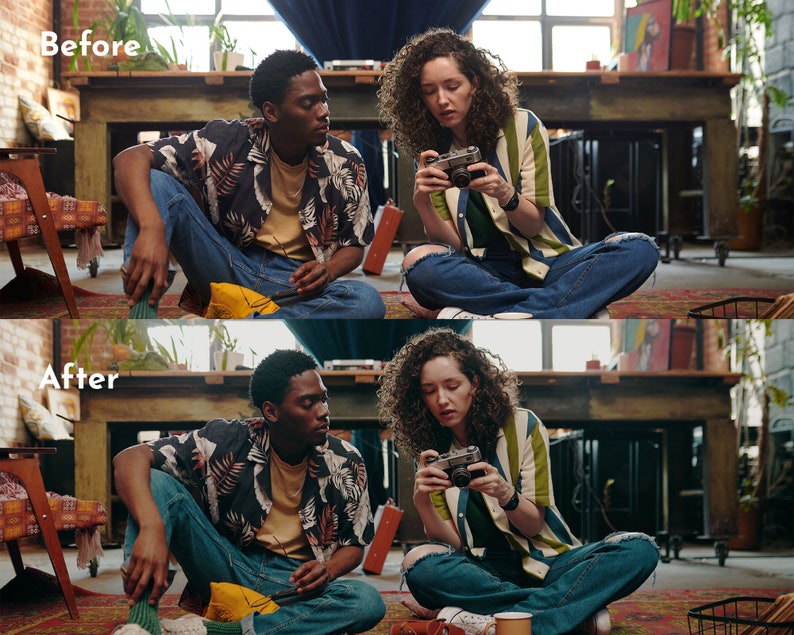 May include: Two people sitting on a rug, one holding a vintage camera. The person on the right is wearing a striped shirt with blue jeans. The person on the left is wearing a floral shirt and blue jeans. The scene is indoors with a table and other items in the background.