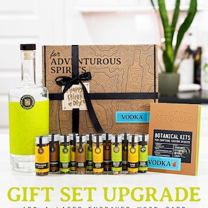 May include: A gift set featuring a clear glass bottle with a green label, a decorative box, and several small glass vials. The box is brown with a black ribbon and a tag that says "Happy Father's Day". The set includes a "Vodka" botanical infusion kit.