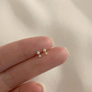 Puede incluir: Un juego de tres tazas de cerámica con un acabado moteado y mate. Las tazas son de color crema, gris claro y gris oscuro. Cada taza tiene un diseño simple y minimalista.