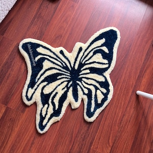 May include: A white and blue butterfly-shaped rug with the text "chickbossshop" on the left wing.