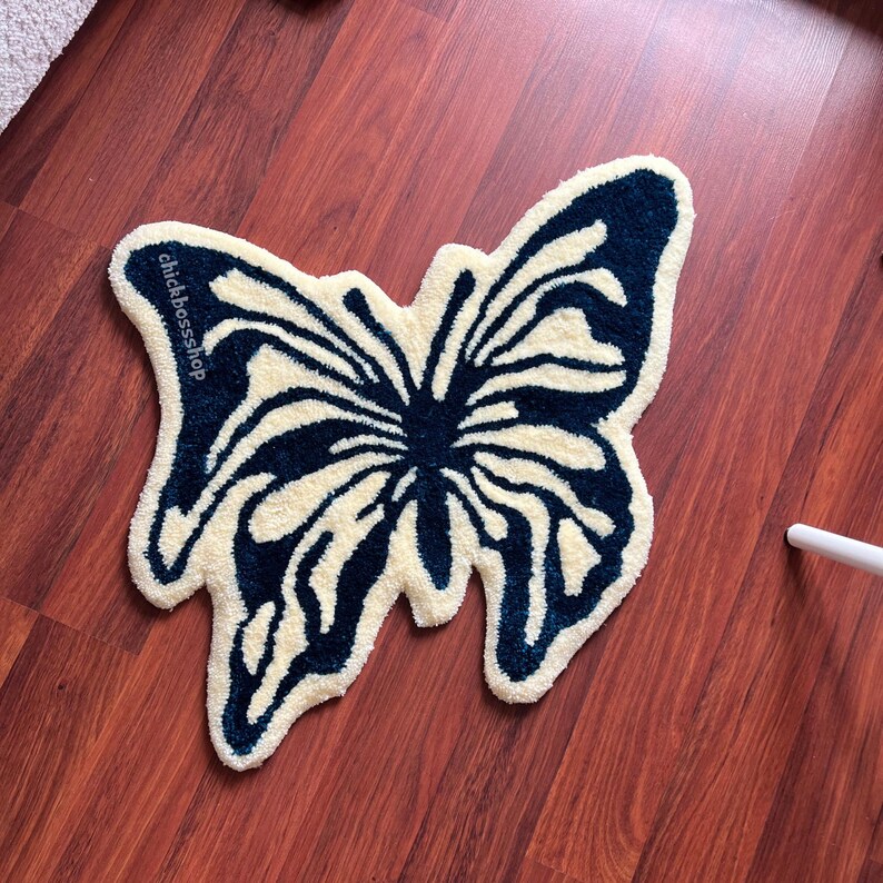 May include: A white and blue butterfly-shaped rug with the text "chickbossshop" on the left wing.