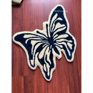 May include: A white and blue butterfly-shaped bath mat. The mat is made of a soft, fluffy material and is perfect for adding a touch of whimsy to your bathroom.