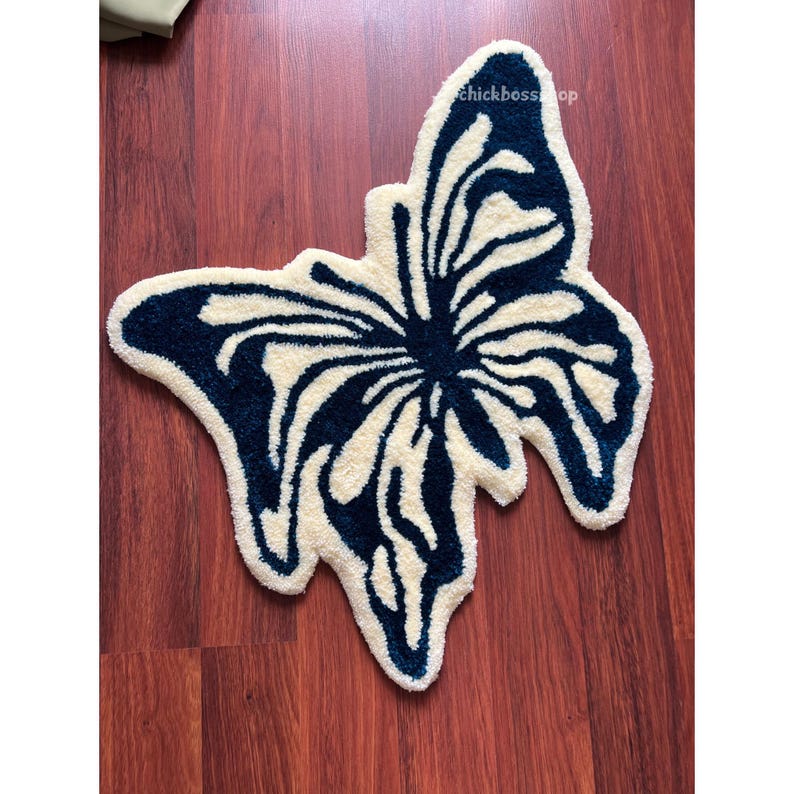 May include: A white and blue butterfly-shaped bath mat. The mat is made of a soft, fluffy material and is perfect for adding a touch of whimsy to your bathroom.