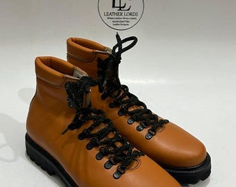 May include: Tan leather ankle boots featuring black laces, black metal eyelets, and a thick black lug sole. A circular logo at the top reads LEATHER LORDS Where Leather Meets Luxury HANDCRAFTED Leather Products.