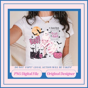 May include: A white t-shirt with a pink and black Halloween design featuring ghosts, a black cat, a skull, a pumpkin, and the words "Boo!" and "Trick or Treat".