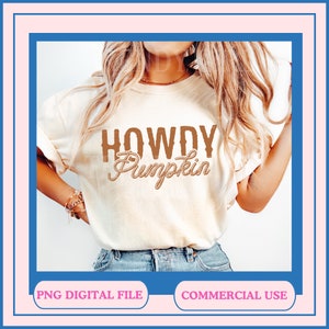 May include: A white t-shirt with the text "Howdy Pumpkin" in brown lettering with a rope design. The text is centered on the shirt.