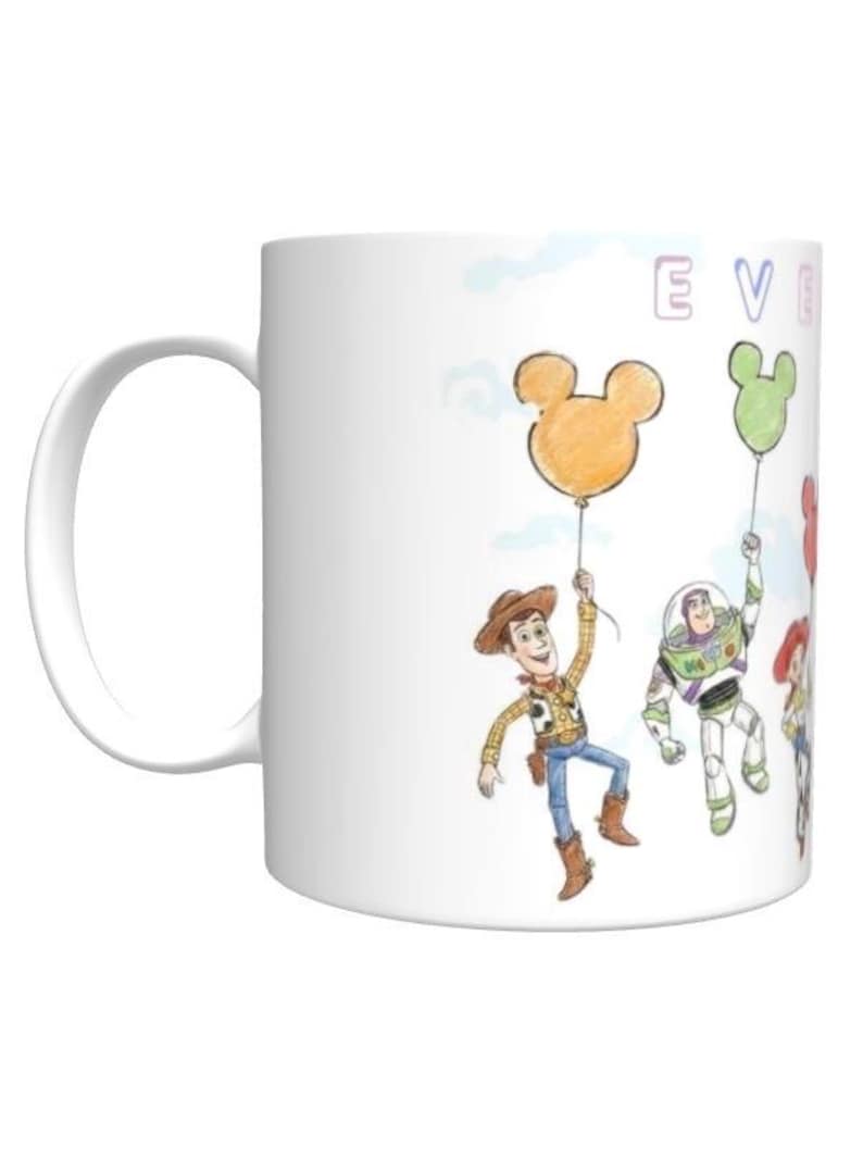 May include: A white ceramic mug with a black handle and the text "But First, Coffee" in a bold, black font. The mug is filled with a dark liquid, likely coffee, and sits on a light-colored surface.