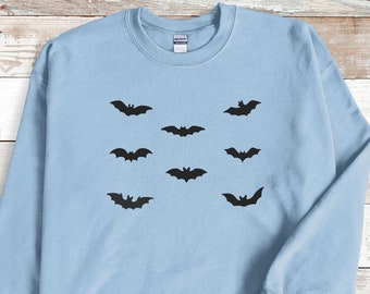 May include: Light blue sweatshirt with a black bat design repeated across the front.