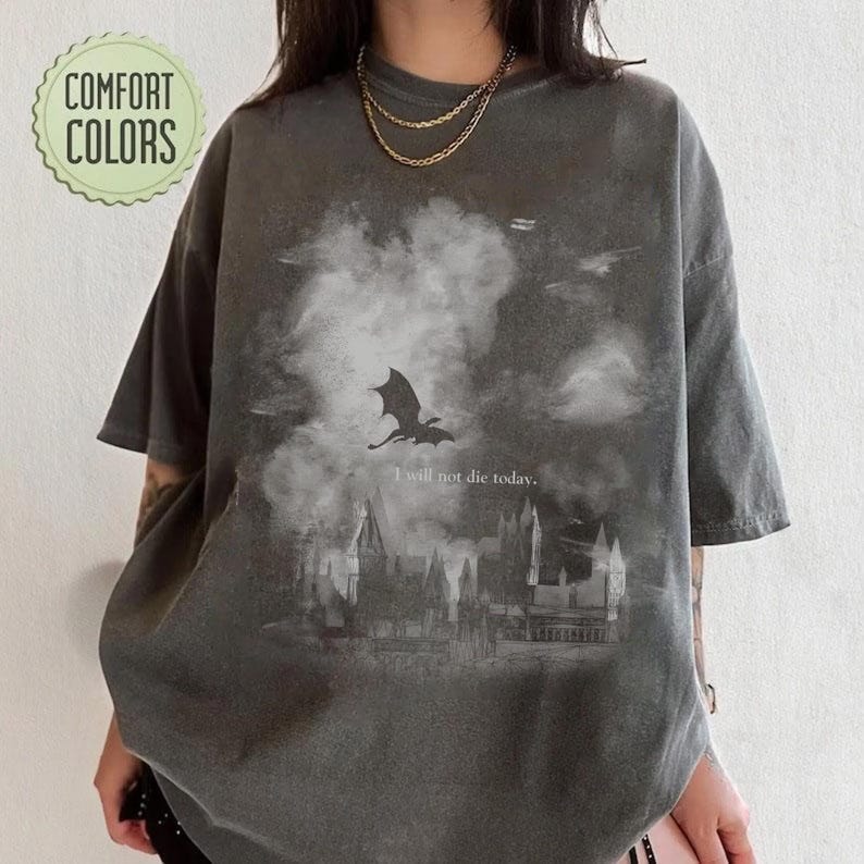 May include: Dark grey t-shirt with a fantasy design, including a dragon, castle, and the phrase "I will not die today." The shirt has a vintage appearance and the words "Comfort Colors" in a green circle.