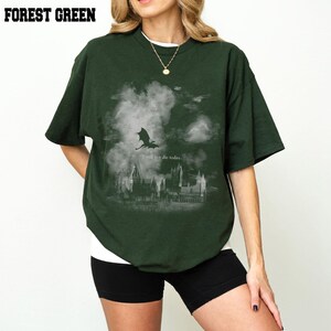May include: Forest green t-shirt featuring a dragon and castle graphic with the text "I will not die today." The dark green shirt has short sleeves. The t-shirt is made of a soft material and is a comfortable fit.