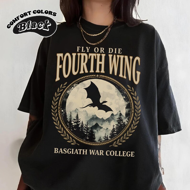 Puede incluir: Camiseta negra con el texto "FLY OR DIE FOURTH WING" y "BASGIATH WAR COLLEGE". El dise&ntilde;o presenta una silueta de drag&oacute;n en un marco circular con una escena de monta&ntilde;a y bosque. La camiseta tambi&eacute;n tiene el texto "COMFORT COLORS Black".