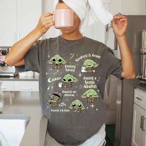K&ouml;nnte beinhalten: Graues T-Shirt mit Cartoon-Illustrationen einer gr&uuml;nen Alien-Figur und den S&auml;tzen "Keeping Strong", "Sleeping 8 Hours", "Cardio", "Having an Arsenal", "Having a Secret Weapon" und "Having a B Plan".