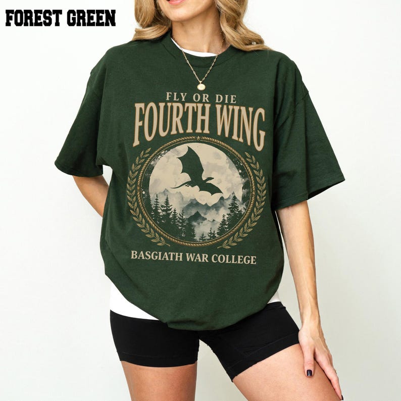 Puede incluir: Camiseta verde bosque con el texto "FLY OR DIE FOURTH WING" y un gr&aacute;fico de un drag&oacute;n frente a un paisaje monta&ntilde;oso. La camiseta tambi&eacute;n tiene el texto "BASGIATH WAR COLLEGE".