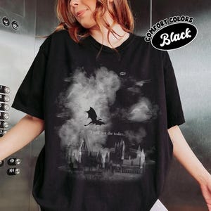 May include: Black t-shirt with a graphic of a dragon, castle, and the text "I will not die today." The shirt has a Comfort Colors label.