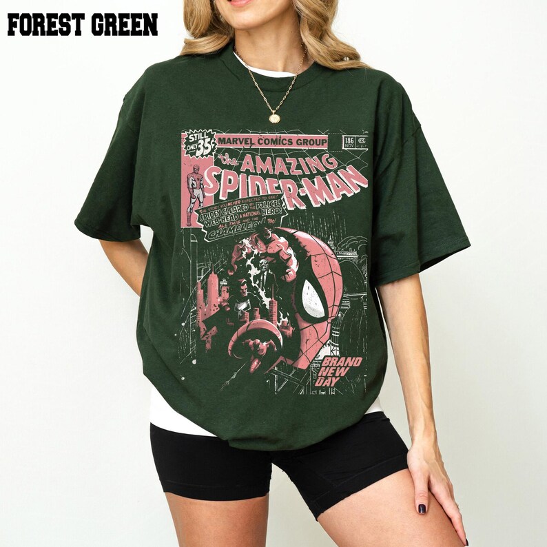 Peut inclure: T-shirt vert for&ecirc;t avec un design de couverture de bande dessin&eacute;e de The Amazing Spider-Man. Le graphisme comprend le personnage de Spider-Man, du texte de bande dessin&eacute;e et le logo Marvel Comics Group. Le t-shirt a des manches courtes et un col rond.