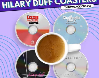 Könnte beinhalten: Vier runde Untersetzer im CD-Design mit Hilary Duff Alben und Soundtracks, darunter The Lizzie McGuire Movie, A Cinderella Story und Breathe In. Breathe Out. Eine weiße Keramiktasse gefüllt mit Kaffee steht auf den Untersetzern.