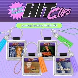 May include: A collection of five square keychains featuring images of Aaron Carter. Each keychain has a silver border, a colorful tassel, and the text "Hit Clips" and "Aaron Carter" on the front. The keychains are part of the "Aaron Carter Pack #1".
