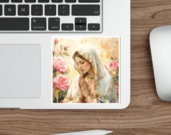 Puede incluir: Una pegatina con una ilustración en acuarela de una mujer con un halo, con las manos juntas en oración, rodeada de rosas rosas. La mujer lleva un velo blanco y una túnica rosa claro con adornos dorados. La pegatina está en un portátil.
